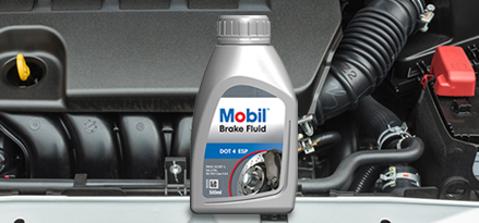 Пляшка гальмівної рідини Mobil Brake Fluid у підкапотному просторі автомобіля